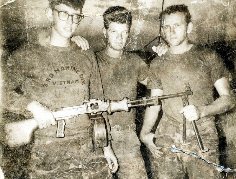 Suel Jones (right) poses with buddies and a captured automatic rifle in Vietnam in the late 1960s.