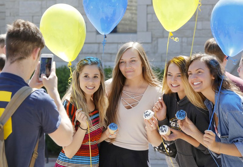 NWA Democrat-Gazette/DAVID GOTTSCHALK Cesia Rodriguez (from left), Abigail Vining, Emma Pitts and Emiley Horton, all freshman at John Brown University, display their celebratory cupcakes and balloons Thursday following the announcement of a $3 million donation to John Brown University in Siloam Springs.