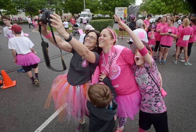 Danna Grear (left) of Fayetteville, Tiffany Blankenship of Bella Vista and her sons Andrew Blankenship (right), 8, and Brooks Blankenship, 4, take a selfie after the survivors parade Saturday during the annual Susan G. Komen Ozark Race for the Cure at Pinnacle Hills Promenade Mall in Rogers. Tiffany Blankenship has been a breast cancer survivor for two years and was also recognized as the top fundraiser for the event.