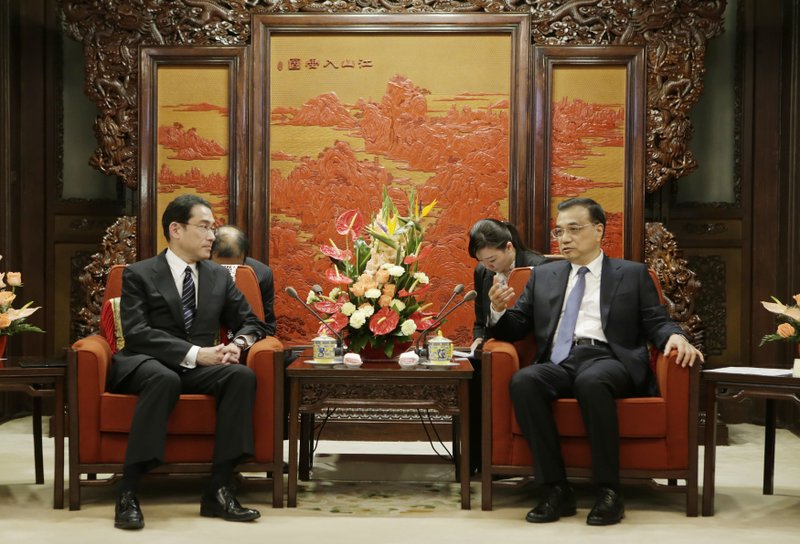 Japanese Foreign Minister Fumio Kishida (left) talks with China’s Premier Li Keqiang during a meeting Saturday at the Zhongnanhai leadership compound in Beijing.