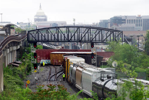 Emergency personnel work the scene of a CSX freight train derailment that spilled hazardous material Sunday, May 1, 2016, in Washington, D.C. The Capitol is seen in the background.