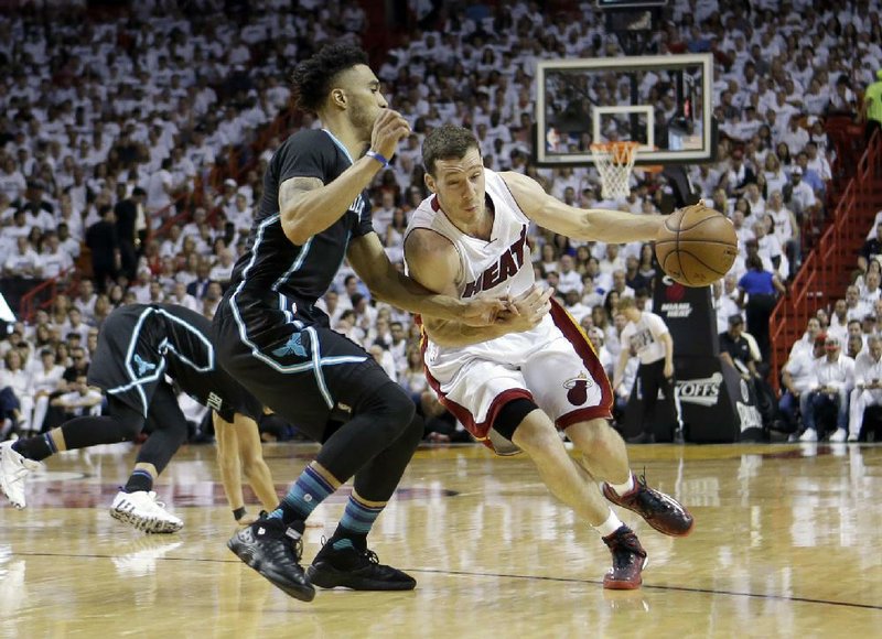 Miami guard Goran Dragic (right) looks for room around Charlotte defender Courtney Lee in Game 7 of their NBA playoff series Sunday. Dragic had 25 points to push the Heat past the Hornets 106-73 and into the Eastern Conference semifinals.