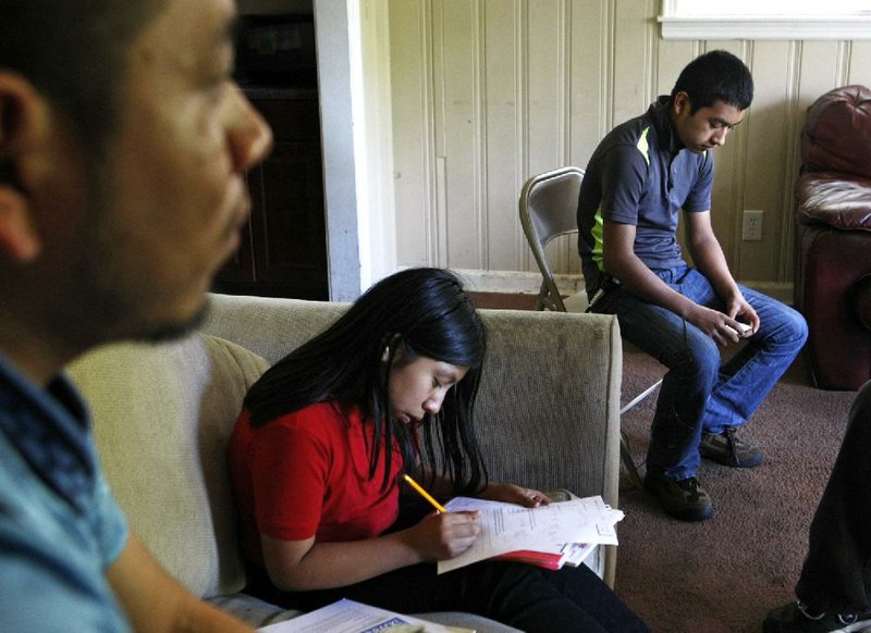 Candelario Jimon Alonzo, 16, (right) sits with his cousin, Melisa Jimon Reynoso (center), and uncle, Domingo Jimon, in their home in Memphis, on April 21. Domingo Jimon took his nephew in after he fled from Guatemala.