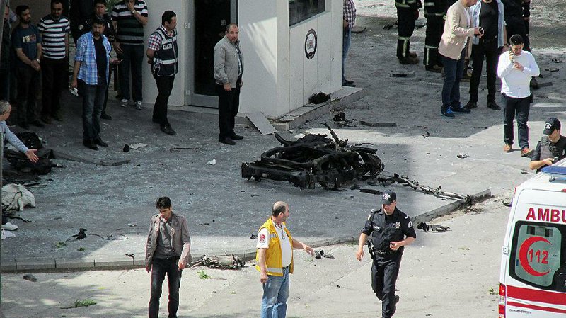 Security and forensic officials and medics investigate around the remains of a car after an explosion outside a police station in Gaziantep, Turkey, on Sunday.
