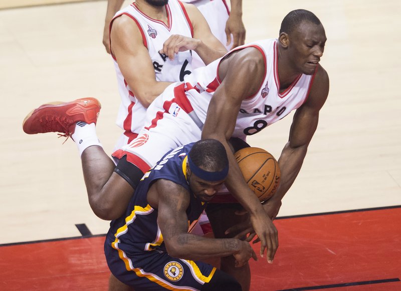 Toronto Raptors center Bismack Biyombo (8) fouls Indiana Pacers guard Ty Lawson (10) during Game 7 of round one NBA playoff basketball action in Toronto on Sunday, May 1, 2016. (Nathan Denette/The Canadian Press via AP)