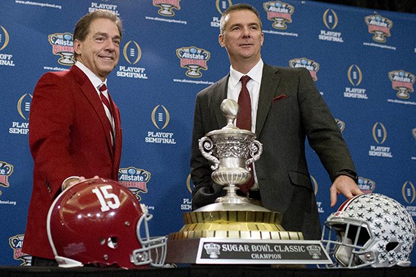 Alabama coach Nick Saban, left, and Ohio State coach Urban Meyer pose with the Sugar Bowl Classic trophy during a press conference at the Marriott downtown convention center in New Orleans, Wednesday, Dec. 31, 2014. (AP Photo/Brynn Anderson)