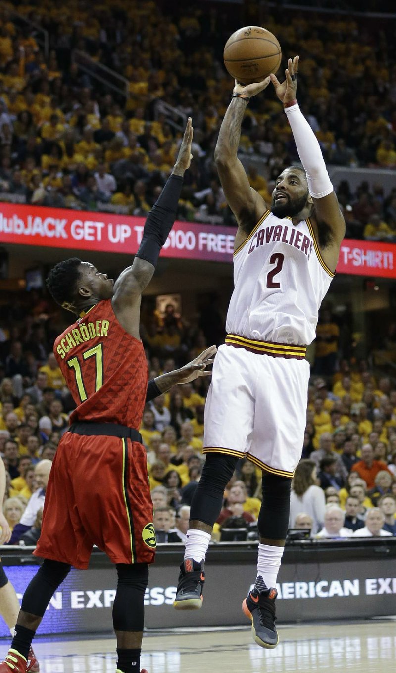 Cleveland guard Kyrie Irving (right) pulls up for a jumper in front of Atlanta defender Dennis Schroder during the second half of Monday night’s NBA playoff game. Irving and the Cavaliers held off a late Hawks’ rally to grab a 104-93 victory and take a 1-0 lead in their Eastern Conference semifinal series.