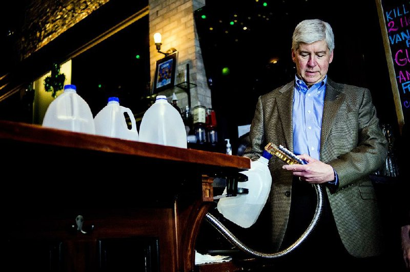 Gov. Rick Snyder fi lls up four one-gallon jugs with Flint water from a bar dispenser at Blackstone’s Pub & Grill on Monday in downtown Flint, Mich.