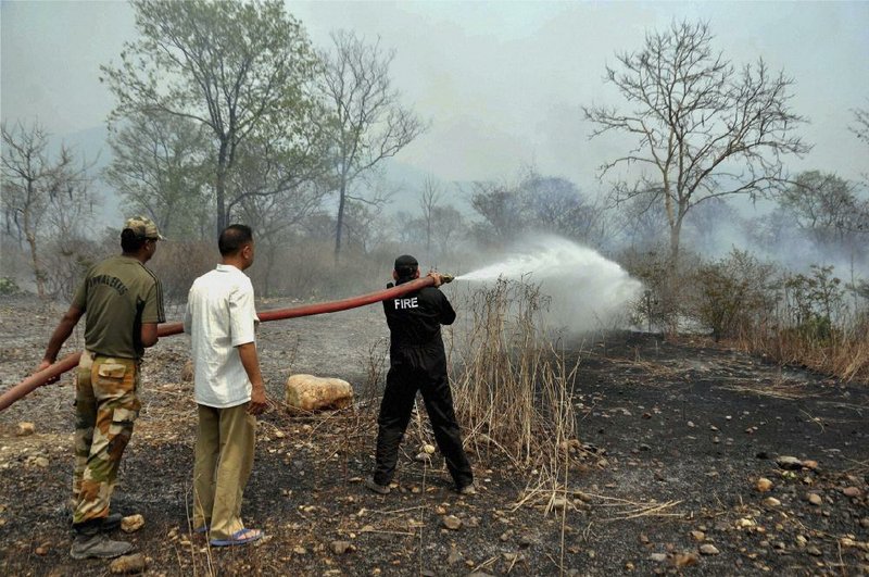 Firefighters try to extinguish a forest fi re in the Maldevta area of Dehradun, India, on Monday.
