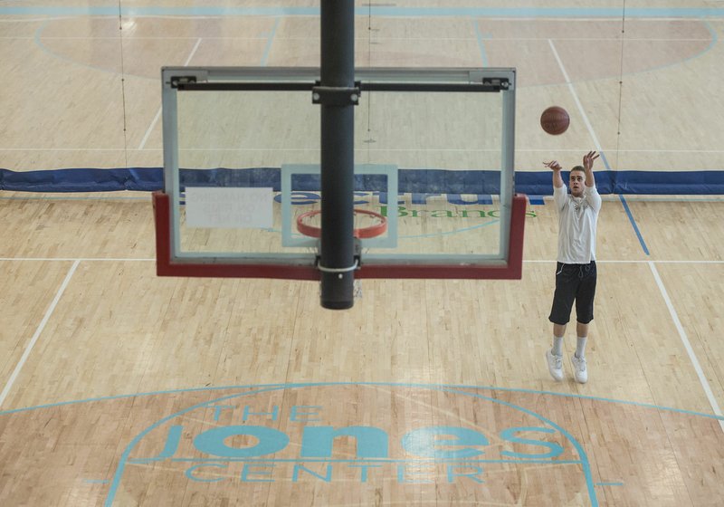 Jeremy Smith shoots baskets Monday at The Jones Center in Springdale. Smith, an employee at the center, often uses the center for personal use and joked he spends more time at the center than at his home.