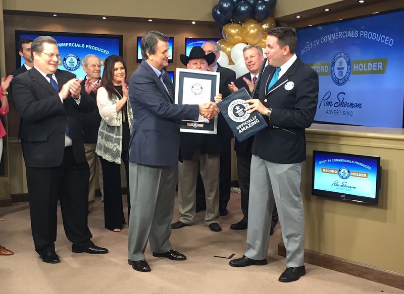 Ron Sherman, founder of Ron Sherman Advertising (center), is joined by Little Rock Mayor Mark Stodola on Tuesday, May 3, 2016, in accepting a Guinness World Record from an organization representative for most TV commercials produced ever. 