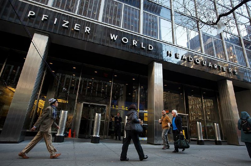 Pedestrians pass Pfizer Inc.’s headquarters in New York in this file photo. The biggest U.S. drugmaker on Tuesday reported a first quarter profit of $3.02 billion. 