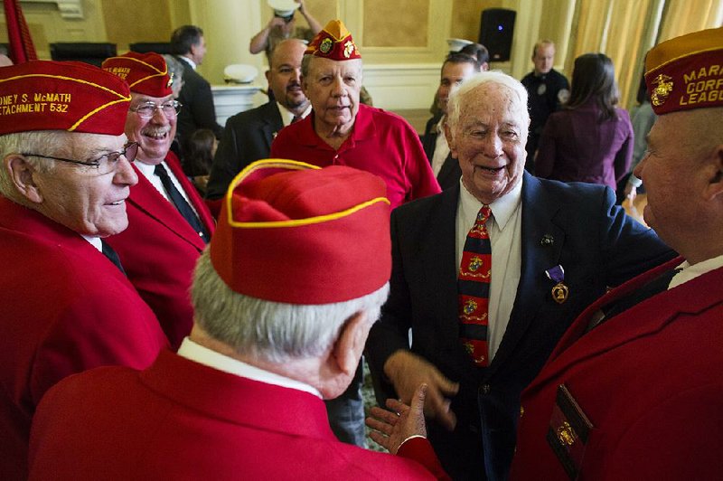 Edsel Smith (in suit) is congratulated by veterans from the Marine Corps League’s Sidney S. McMath Detachment at the state Capitol in Little Rock, where Smith received the Purple Heart on Tuesday. 