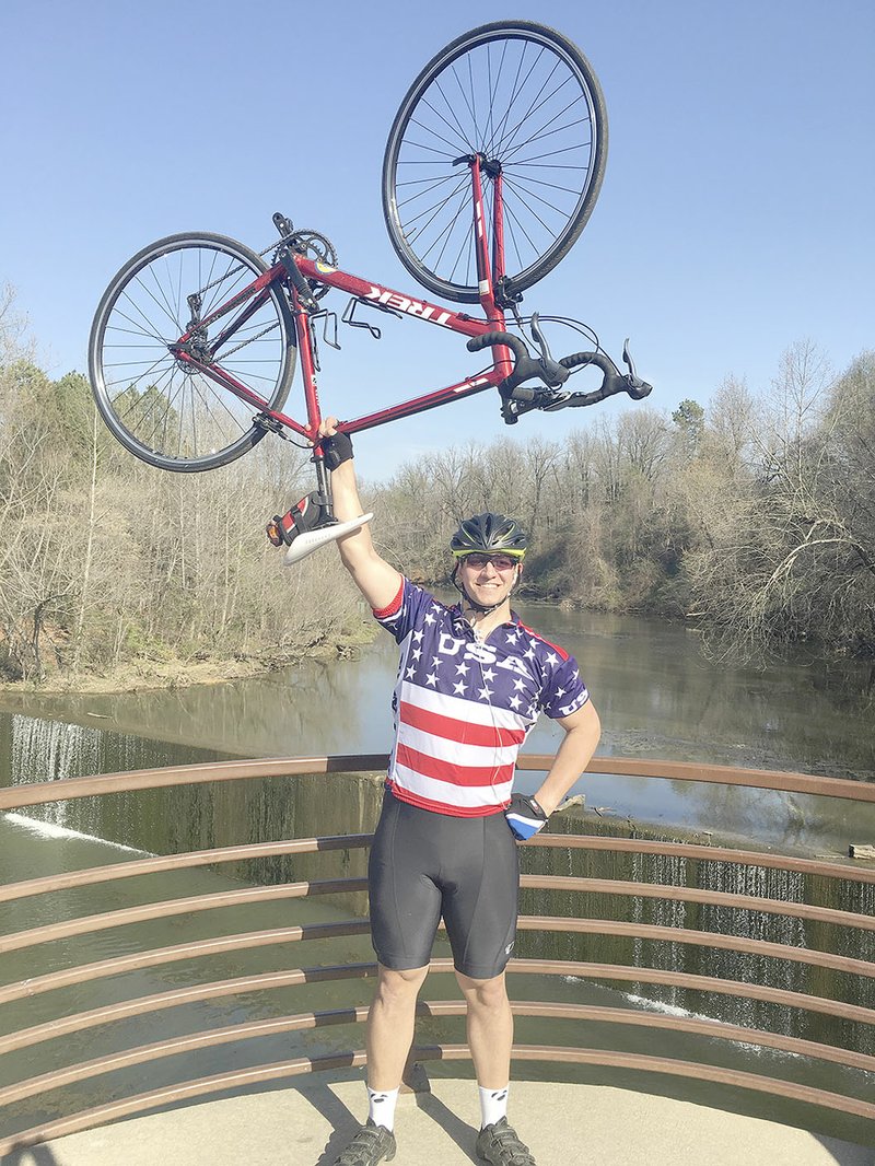 SUBMITTED PHOTO Michael Bond, a senior at University of Arkansas and graduate of Prairie Grove High School, trains on the Razorback Greenway and Fayetteville biking trails for a bike ride across the country this summer.