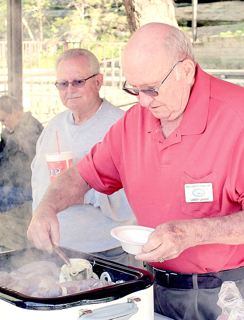 Photo submitted Chief Chef Larry Lamar serves up a bowl of grub during the Bella Vista Fly-Tyiers picnic in Blowing Springs Park.