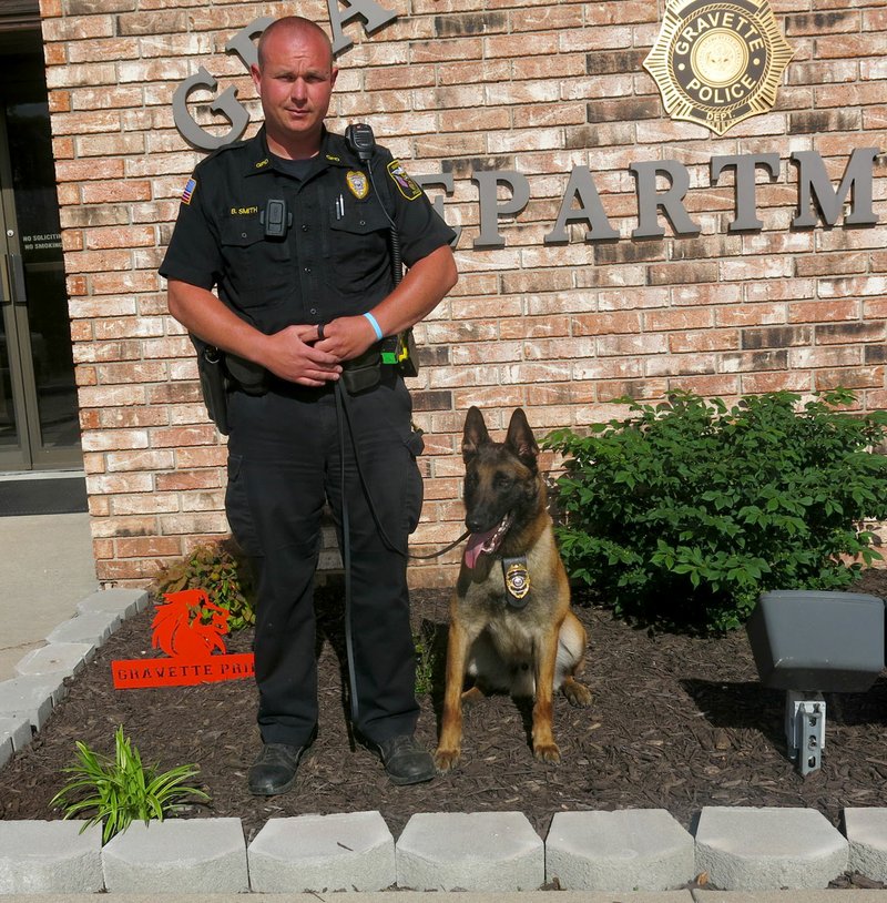 Photo by Susan Holland Two new reserve officers were sworn in at the Gravette police department last Thursday. Officer Bryan Smith poses with the third new member of the department, canine officer Ikks Du Monts Lerroux, a 2 1/2 year old Belgian Malinois. Officer Smith and Ikks have just completed their handler&#8217;s course and Ikks will be hitting the streets this week when his new patrol vehicle is fitted out.