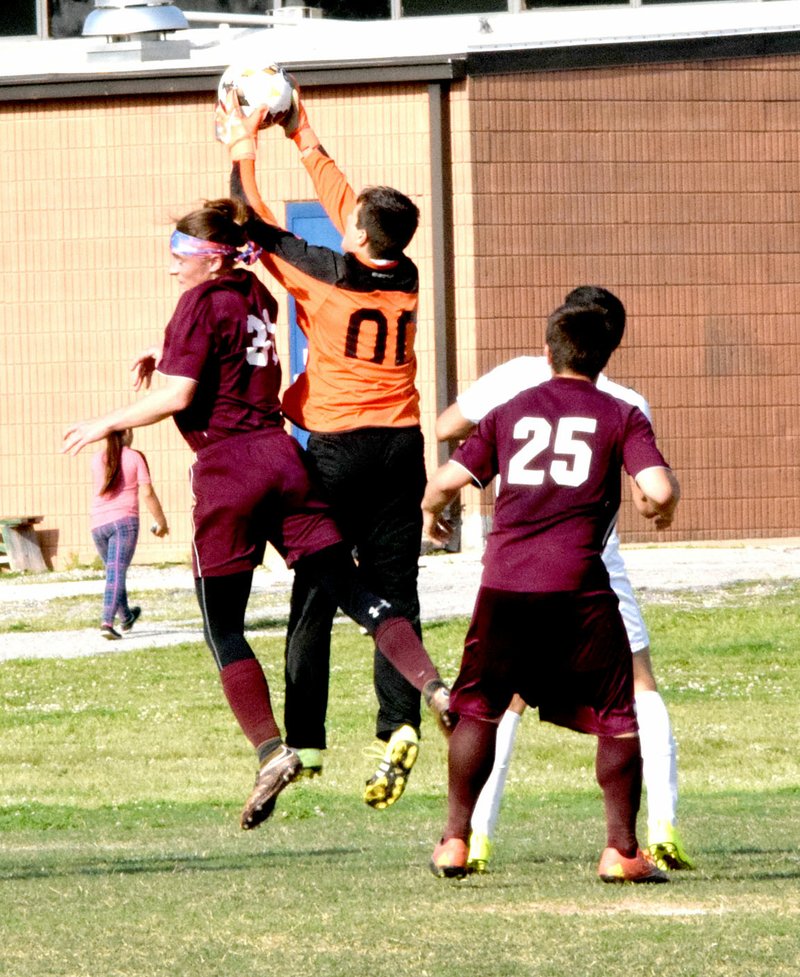 Photo by Mike Eckels David Lopez (Decatur goal keeper #00) robs Eli Podoll (left, Huntsville #31) of a head shot into the net during the Decatur-Huntsville conference soccer match at Bulldog Stadium in Decatur April 26. The Eagles took the match, 2 to 1.