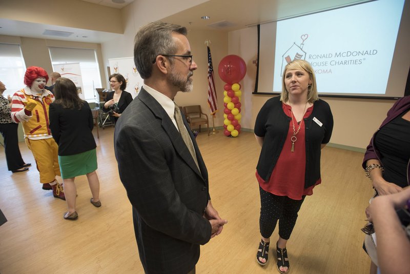 In this file photo Tim Hudson (left), executive director of the Washington Regional Medical Foundation, visits  Leah Jones, director of operations for Ronald McDonald House Charities of Arkoma.