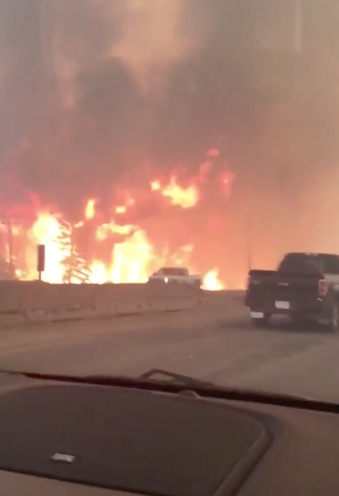 This photo provided by Tyler Burgett shows flames from a wildfire along Highway 63 in Fort McMurray, Alberta, Tuesday, May 3, 2016. 