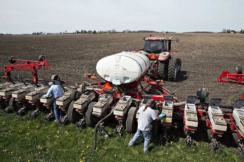 Farmers load DuPont Pioneer hybrid corn into a planter in a field in Princeton, Ill., in mid-April. A recent rally in corn prices, to about $4 a bushel, led to a jump in sales from U.S. farmers who are sitting on a large amount of the grain in storage. 