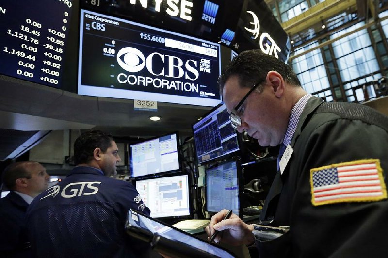 Trader Edward Curran (right) works Wednesday near the post that handles CBS Corp. shares on the floor of the New York Stock Exchange. 