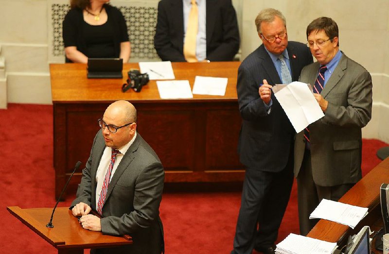 Sen. Jeremy Hutchinson (left), R-Little Rock, takes questions Wednesday on the Senate floor about a proposed change in the Capitol Zoning District Commission appropriation bill. Sen. Keith Ingram (second from right), D-West Memphis, and Sen. Larry Teague, D-Nashville, confer during the discussion.