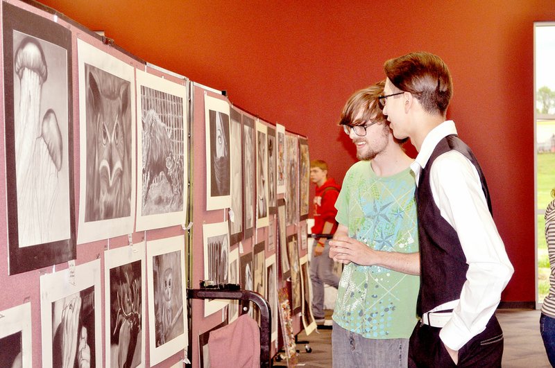 RACHEL DICKERSON MCDONALD COUNTY PRESS Ben Reese and Cody Latty look at the art on display during the grand opening of the performing arts center at McDonald County High School.