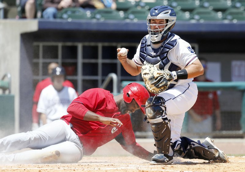Chris Jacobs of the Springfield Cardinals slides in safe Wednesday behind a late throw at the plate to the Northwest Arkansas Naturals’ Allan de San Miguel during the sixth inning at Arvest Ballpark in Springdale.