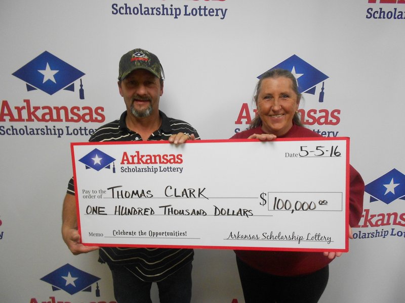 Thomas Clark, left, and his wife, Linda, stand with his $100,000 lottery prize. 
