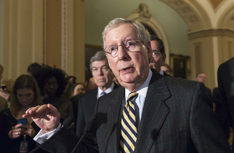 Senate Majority Leader Mitch McConnell of Ky., flanked by Sen. Roy Blunt, R-Mo., left, and Sen. John Barrasso, R-Wyo., right rear, talks to reporters on Capitol in Washington, Tuesday, March 8, 2016, following a closed-door policy meeting.  