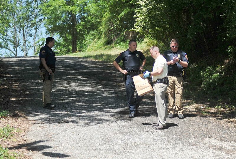 Hot Springs police gather evidence after a shooting in Wade Street Park on Thursday. 
