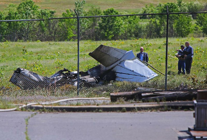 5/5/16
Arkansas Democrat-Gazette/STEPHEN B. THORNTON
Investigators walk near the remains of a plane that crashed Thursday and caught fire, killing one and injuring another at the North Little Rock Municipal Airport.