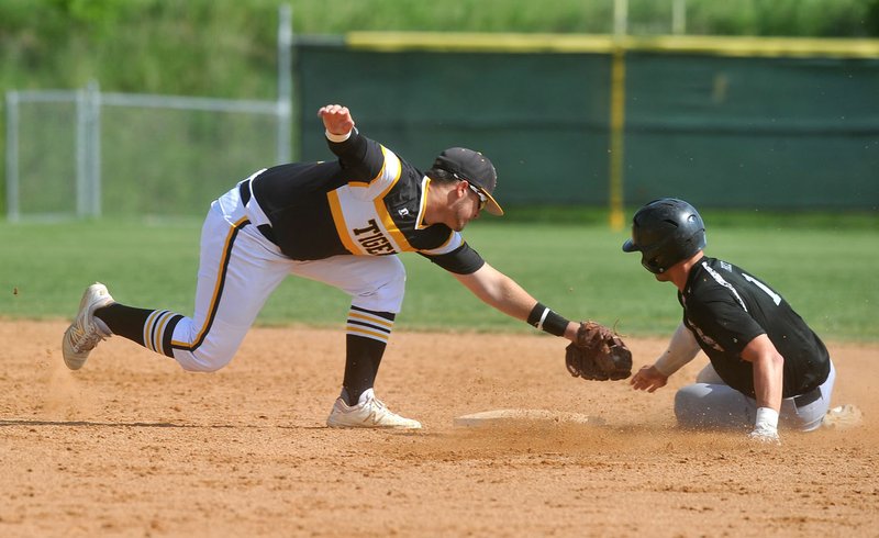 Prairie Grove short stop Sam Dodd (6) tries Thursday to tag Dover baserunner Luke Price (1) as he slides into second base during the 4A North Regional Tournament in Prairie Grove.