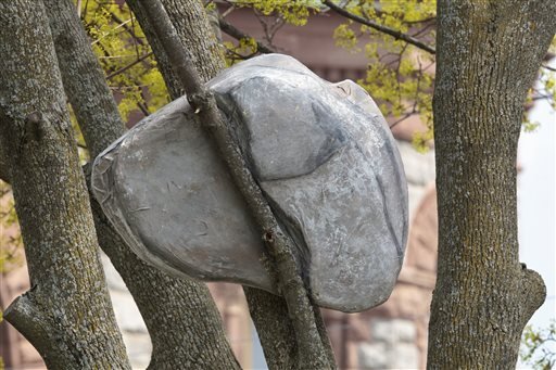 This photo taken Thursday, May 5, 2016, shows part of the installation, titled "IMPOSSIBLE," created by Andy Moerlein, that features specifically placed rock sculptures in various trees around at Hackley Park in Muskegon, Mich. 
