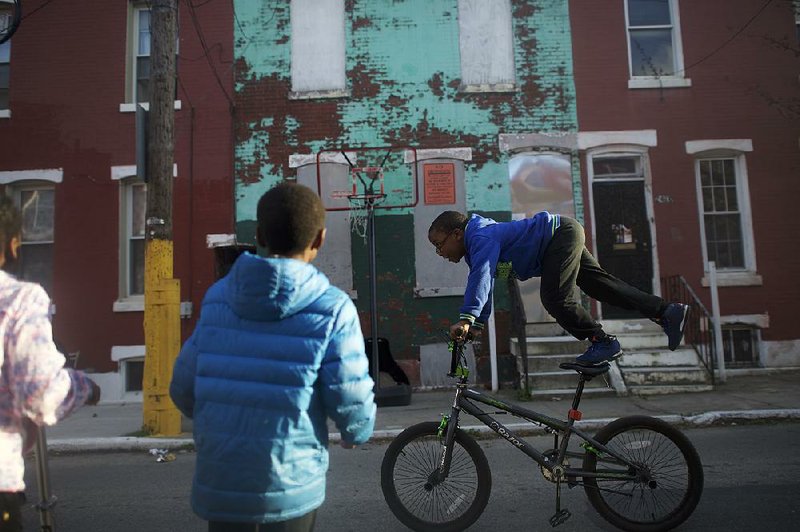 Schoolchildren play in front of an abandoned building in the Sharswood neighborhood of Philadelphia last month. 