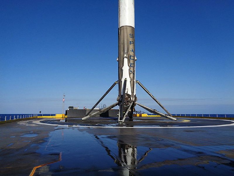 SpaceX’s booster rocket sits on a platform Friday in the Atlantic Ocean just off the Florida coast after launching a Japanese communications satellite. 