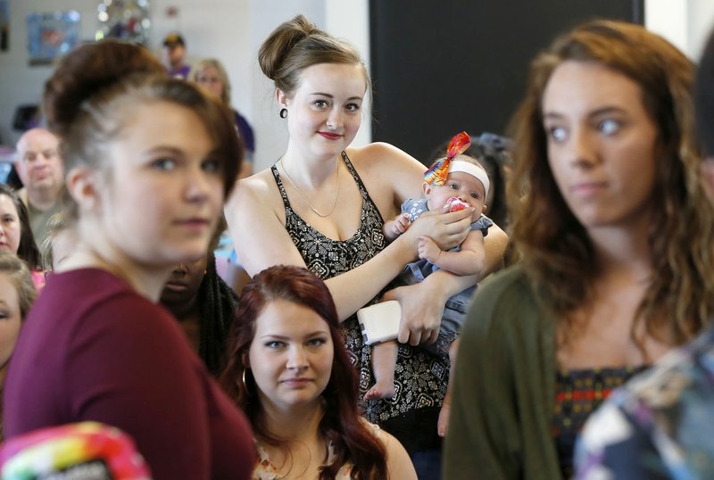 Avery Undernehr, a senior at Agee Lierly Life Preparation Services Center, stands with her daughter Clara Ginnett, 3-months, as she stands with classmates Friday while being honored for a high grade point average during the ALLPS Senior Celebration at the school in Fayetteville. Graduating students from the innovation and alternative program of Fayetteville High School were honored for achievements and listened to inspirational messages from Paul Hewitt, superintendent of Fayetteville Schools, Ugochi Iloka, a television reporter and Steve Clark, president and chief executive officer of the Fayetteville Chamber of Commerce.