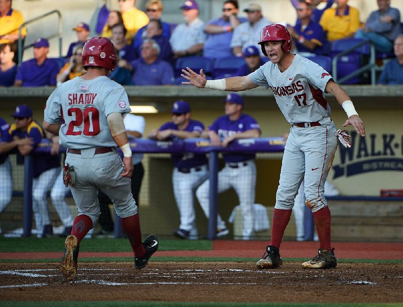Arkansas designated hitter Luke Bonfield (right) greets center fielder Carson Shaddy at home plate after they both scored on Jake Arledge’s RBI double in the first inning of the Razorbacks’ 10-9, 10-inning loss to LSU on Saturday at Alex Box Stadium in Baton Rouge.