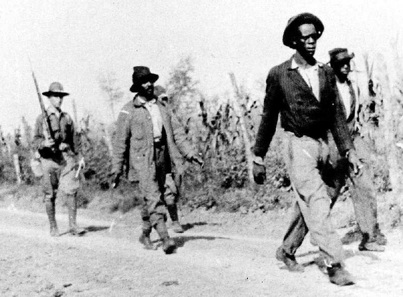 Federal troops escort blacks on a road near Elaine in the fall of 1919 after what historians have called one of the deadliest racial confrontations in U.S. history. Tourism officials hope to raise awareness of Elaine as an important site in the civil-rights struggle, as well as draw visitors to the Phillips County town.