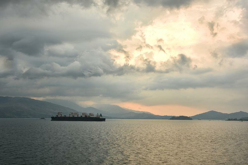 A cargo ship sails through Subic Bay, Philippines. The former U.S. military base is now a commercial port where American and Chinese ships pass in close proximity.