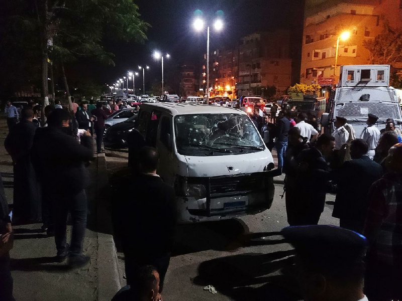 Egyptian police and civilians gather Sunday around a bullet-riddled microbus in the south Cairo neighborhood of Helwan after Islamic State-linked gunmen opened fi re, killing eight policemen, officials said.