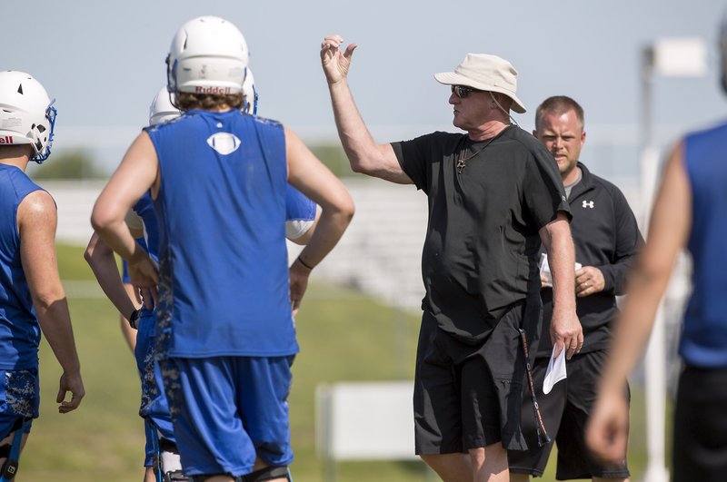 Mike Loyd works his team on Thursday during practice at Rogers High School. Loyd is the new head coach for the Mounties.