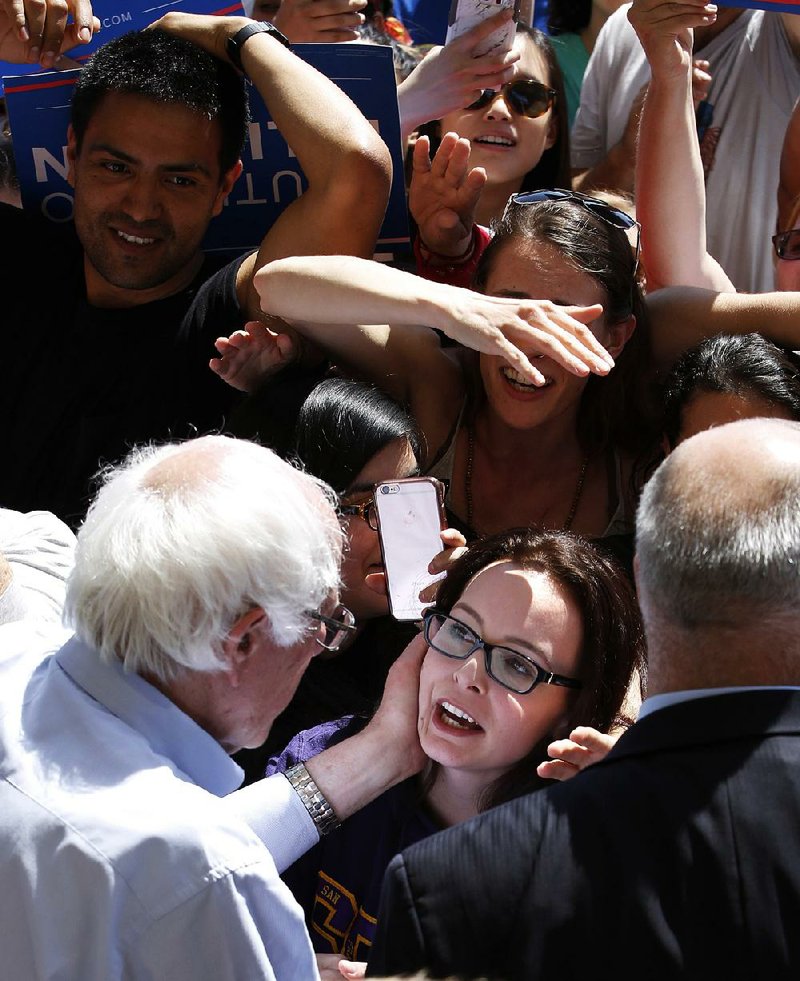 Bernie Sanders talks with a supporter after a rally Tuesday in Stockton, Calif. Sanders said there was no question his campaign “is energizing the American people.” 