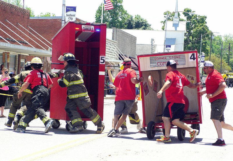 Photo by Randy Moll Main Street in neighboring Southwest City (Mo.) was the scene of a parade and a downhill run of outhouses during Old Timers&#8217; Day on Saturday. This Main Street fire drill of sorts proved entertaining as outhouse crews from the Southwest City Volunteer Fire Department and the Cornerstone Station raced around their outhouses at a set point along the route.