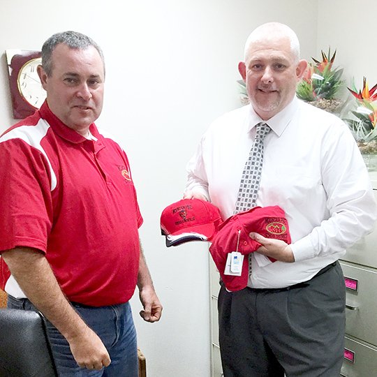 Submitted photo MP GEAR: Mountain Pine School Board President Tom Gould, left, presented Red Devil gear to Bobby Joe Applegate Monday after the board voted to hire him as the next superintendent. Bobby Gray will retire at the end of the school year.