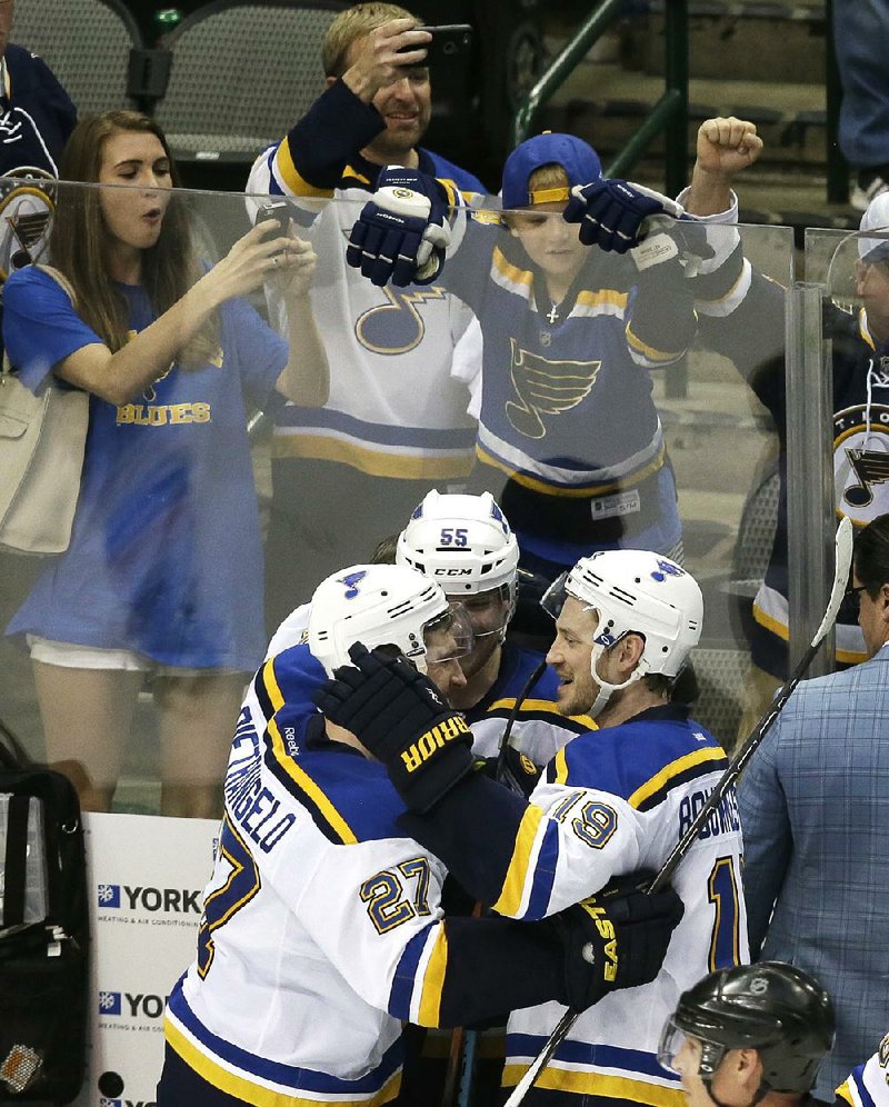 Alex Pietrangelo (27), Colton Parayko and Jay Bouwmeester (19) of the St. Louis Blues celebrate their 6-1 victory over the Dallas Stars on Wednesday in Dallas. 