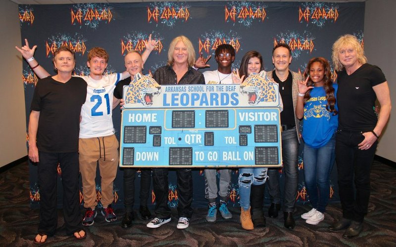 Def Leppard poses for a photo with several Deaf Leopards from the Arkansas School for the Deaf Wednesday at Verizon Arena. 