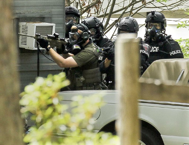 Little Rock police officers urge Jorge Nunez to come out of his ex-girlfriend’s home before they threw tear gas canisters into the building Thursday. 