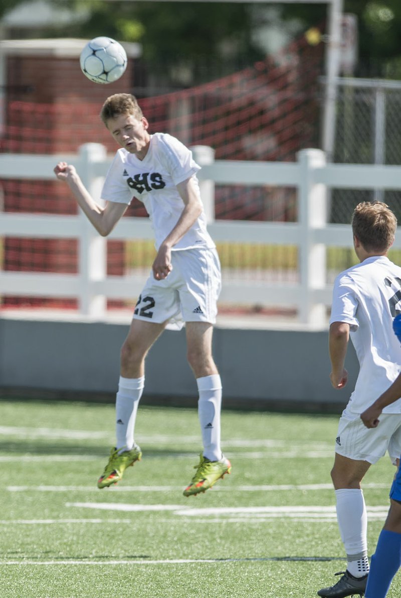 Ethan Smith, Bentonville junior, heads the ball Thrusday against North Little Rock during the 7A state soccer tournament at Jarrell Williams Bulldog Stadium in Springdale. The Tigers won 7-0.