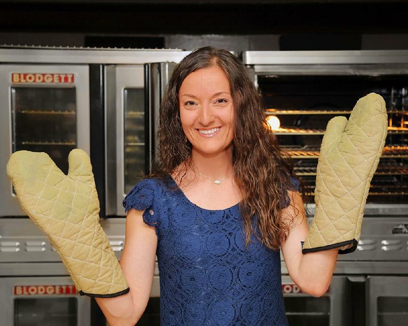 Opa, y’all! Jamie Groat, communication chairman for the 32nd annual International Greek Food Festival, dons oven mitts to help out in the Annunciation Greek Orthodox Church kitchen for the forthcoming three-day event. 